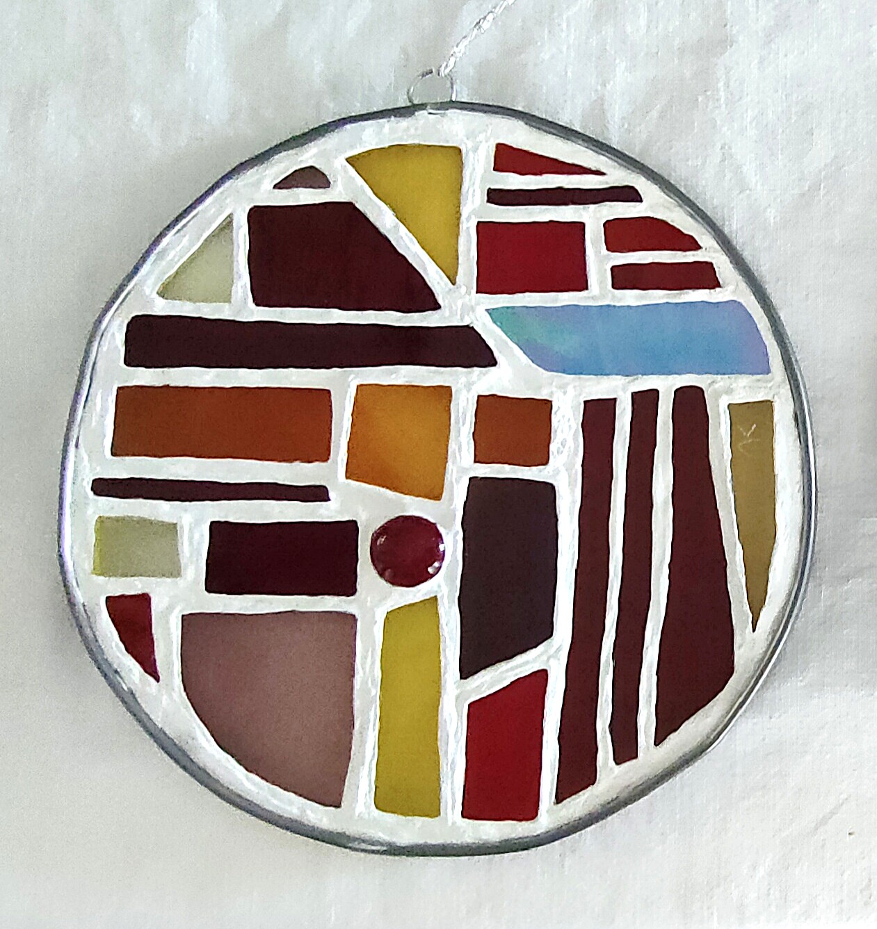 Vitrail de petite taille, prêt à être suspendu, dans les tons bleus et rouges